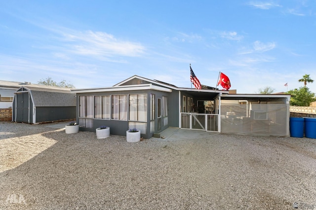 view of front of house featuring a sunroom and a storage unit