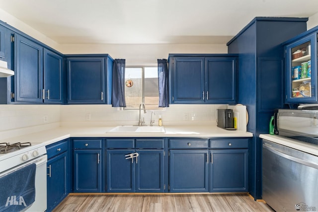 kitchen featuring decorative backsplash, white gas range, blue cabinets, and sink