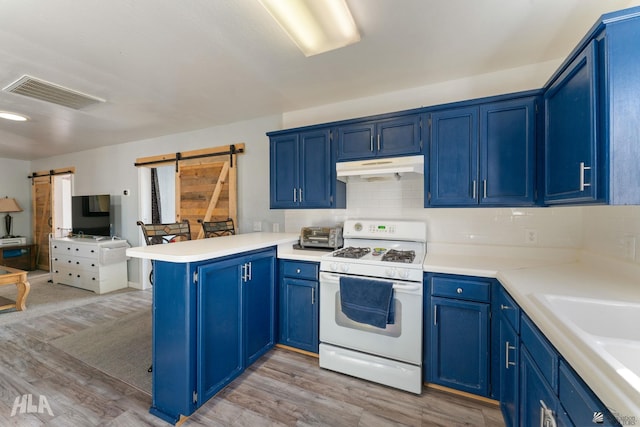 kitchen with a barn door, white range, and blue cabinets