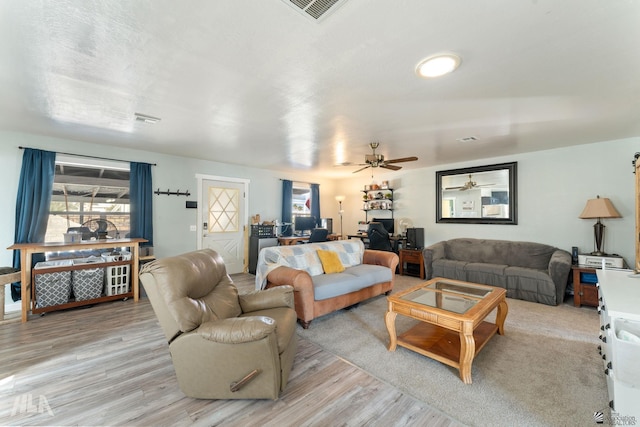 living room featuring ceiling fan and light hardwood / wood-style flooring