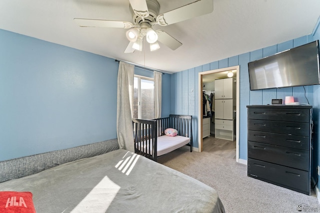 carpeted bedroom featuring a walk in closet, ceiling fan, and a closet