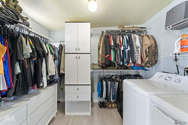 spacious closet featuring washer and clothes dryer and light wood-type flooring