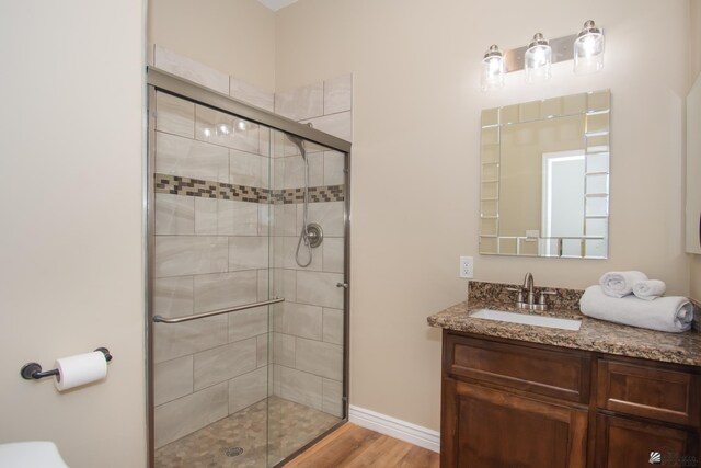 bathroom featuring vanity, wood-type flooring, and an enclosed shower