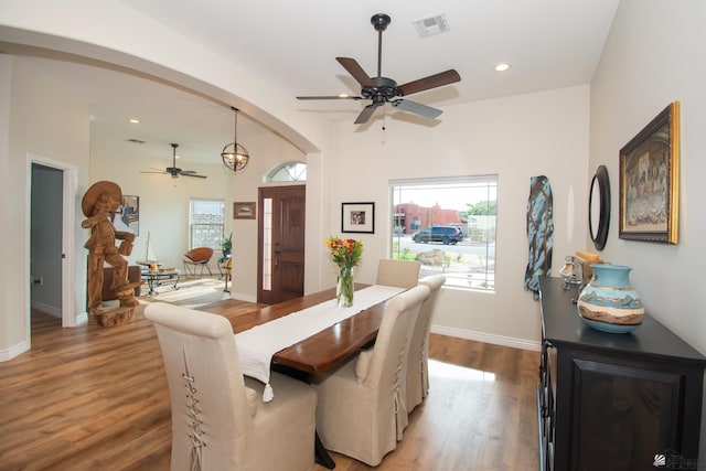 dining area featuring hardwood / wood-style floors and ceiling fan with notable chandelier