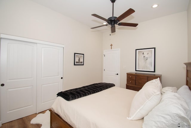 bedroom featuring hardwood / wood-style flooring, ceiling fan, and a closet