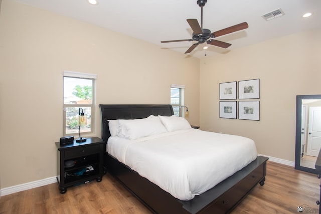 bedroom featuring multiple windows, light hardwood / wood-style floors, and ceiling fan