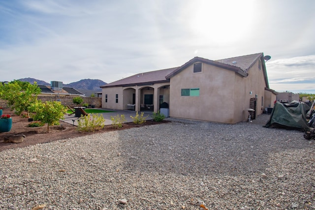 rear view of house with a mountain view and a patio