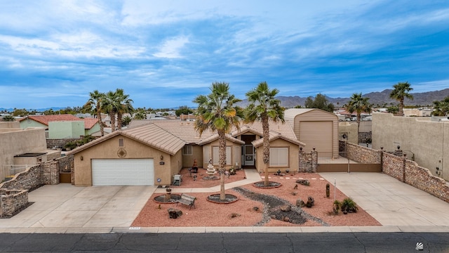 view of front of home with a tile roof, stucco siding, a mountain view, a garage, and driveway