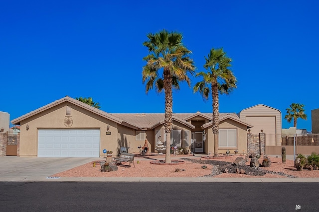 view of front of house featuring an attached garage, fence, a tile roof, driveway, and stucco siding