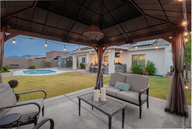 view of patio with exterior bar, a gazebo, an outdoor living space, and a fenced in pool