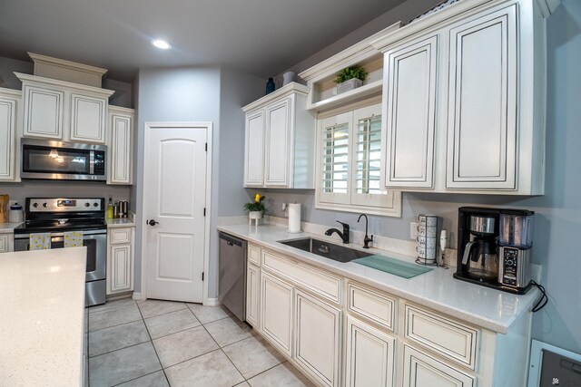 kitchen featuring light tile patterned floors, stainless steel appliances, and sink