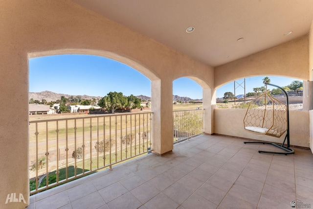 view of patio with a balcony and a mountain view