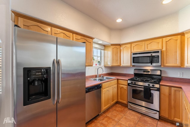 kitchen with light brown cabinetry, appliances with stainless steel finishes, light tile patterned floors, and sink