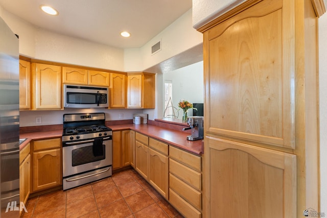 kitchen featuring appliances with stainless steel finishes and dark tile patterned floors