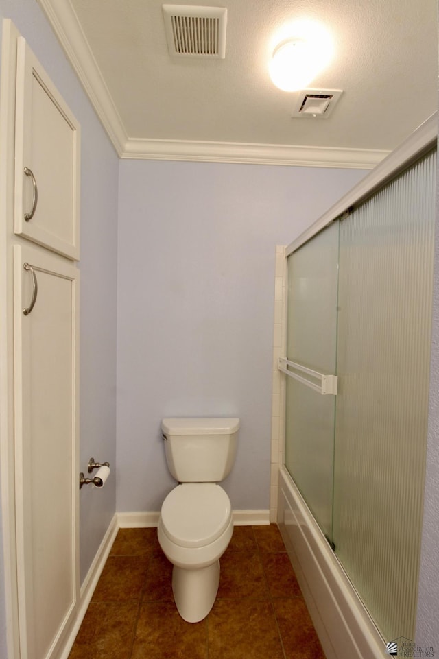 bathroom featuring crown molding, combined bath / shower with glass door, tile patterned floors, and toilet