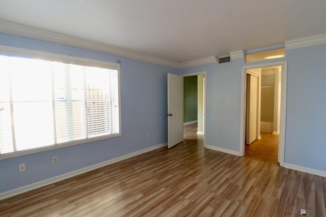 unfurnished room with ornamental molding and light hardwood / wood-style floors