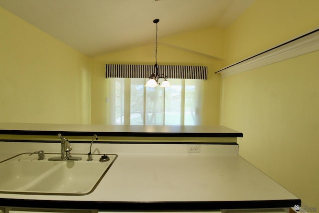 kitchen with sink, decorative light fixtures, vaulted ceiling, and a chandelier