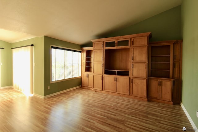 unfurnished living room featuring vaulted ceiling and light wood-type flooring