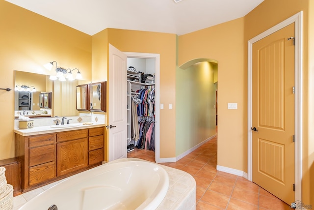 bathroom with vanity, tiled tub, and tile patterned floors