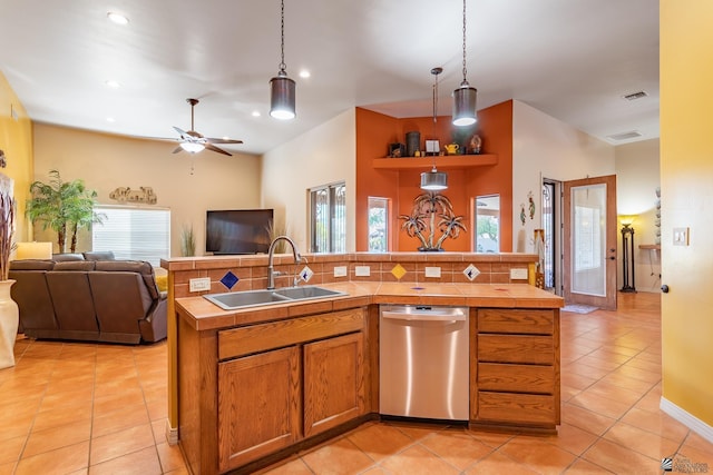 kitchen with pendant lighting, sink, stainless steel dishwasher, and an island with sink