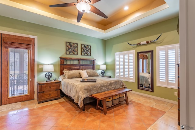 tiled bedroom with a raised ceiling and ceiling fan