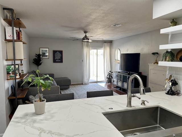 interior space featuring light stone countertops, a sink, and open shelves