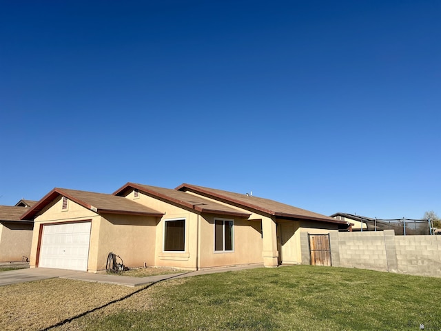 view of front of home featuring a front lawn, fence, an attached garage, and stucco siding