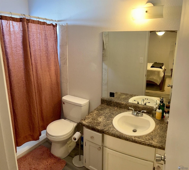 bathroom with curtained shower, vanity, and toilet