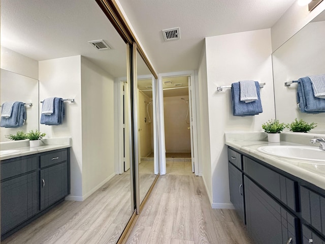 bathroom featuring a textured ceiling, vanity, and hardwood / wood-style flooring