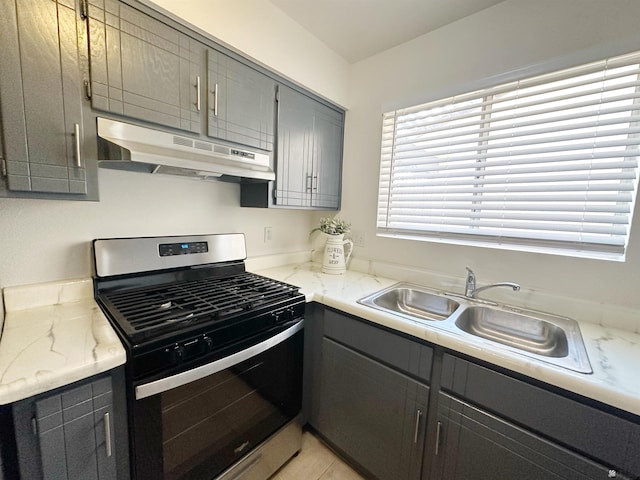 kitchen with gray cabinetry, gas stove, and sink