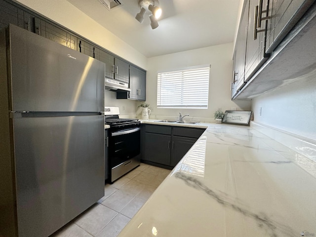 kitchen with sink, ceiling fan, light stone countertops, light tile patterned floors, and stainless steel appliances