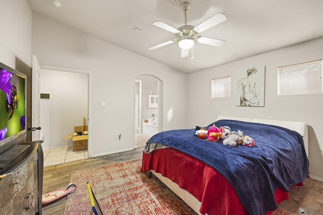 bedroom featuring ceiling fan, ensuite bath, and wood-type flooring