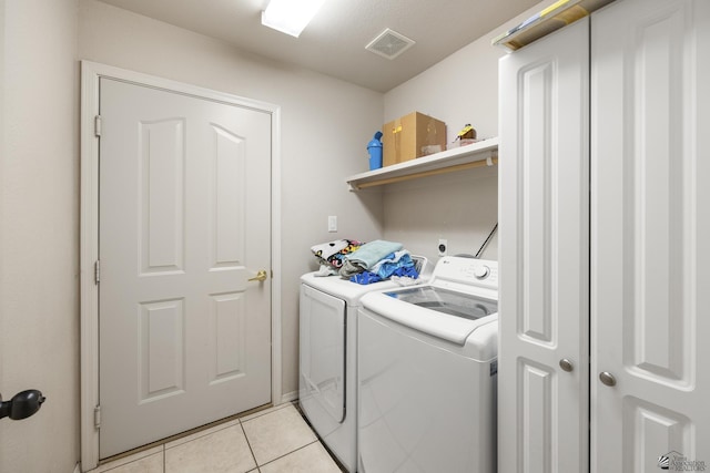 clothes washing area featuring washing machine and clothes dryer and light tile patterned floors