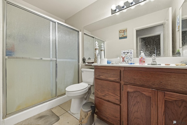 bathroom featuring toilet, an enclosed shower, vanity, and tile patterned floors