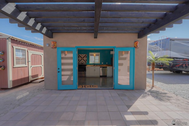 view of patio / terrace with a sink, an outdoor structure, and a pergola