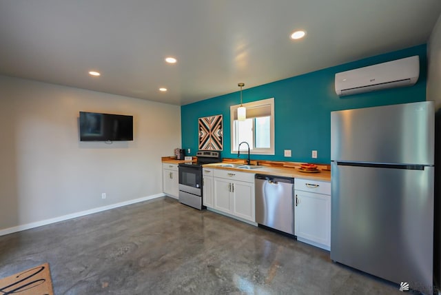 kitchen featuring a wall mounted air conditioner, concrete flooring, white cabinets, stainless steel appliances, and a sink