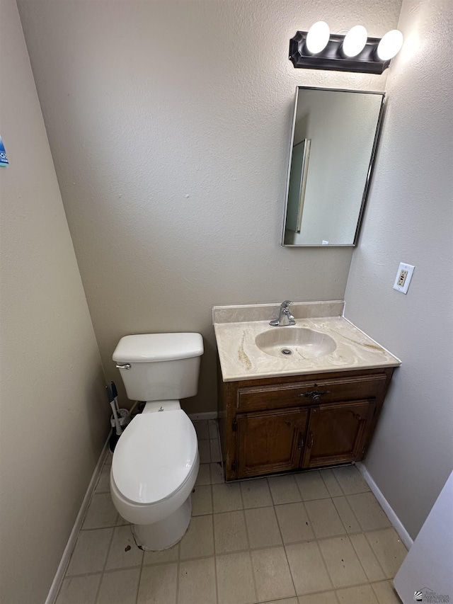 bathroom featuring vanity, toilet, and baseboards