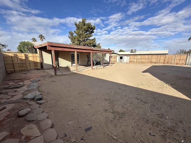 back of property featuring a fenced backyard, a patio area, and an outdoor structure