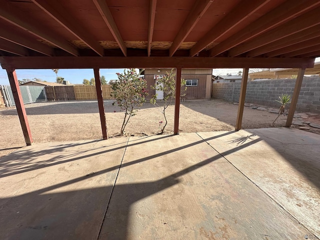 view of patio with a storage shed, an outbuilding, and a fenced backyard