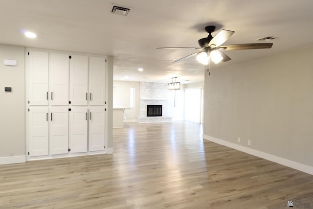 unfurnished living room featuring a fireplace, ceiling fan, and light hardwood / wood-style flooring