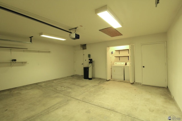 garage with separate washer and dryer and a garage door opener