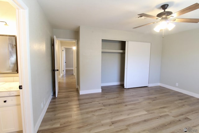 unfurnished bedroom with ensuite bath, ceiling fan, light hardwood / wood-style floors, and a closet