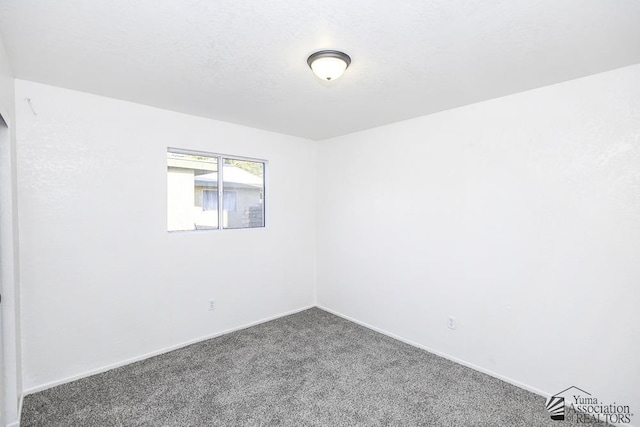 empty room featuring carpet flooring and baseboards