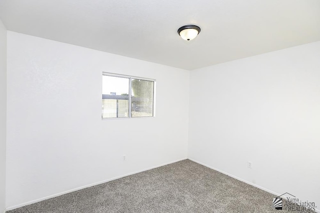 carpeted spare room featuring baseboards