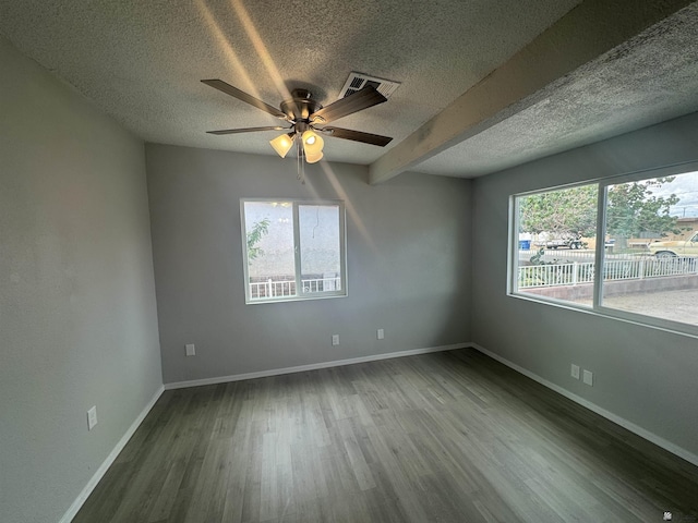 empty room featuring a wealth of natural light, baseboards, and wood finished floors