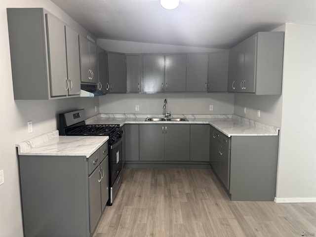 kitchen with gray cabinets, a sink, gas stove, light wood-style floors, and extractor fan