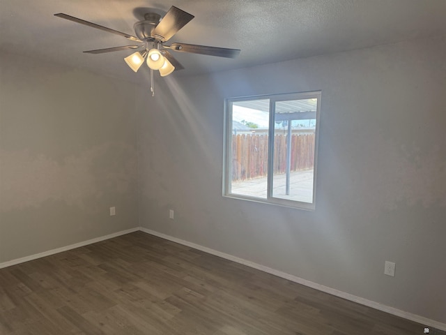 spare room with baseboards, a ceiling fan, dark wood-style flooring, and a textured ceiling