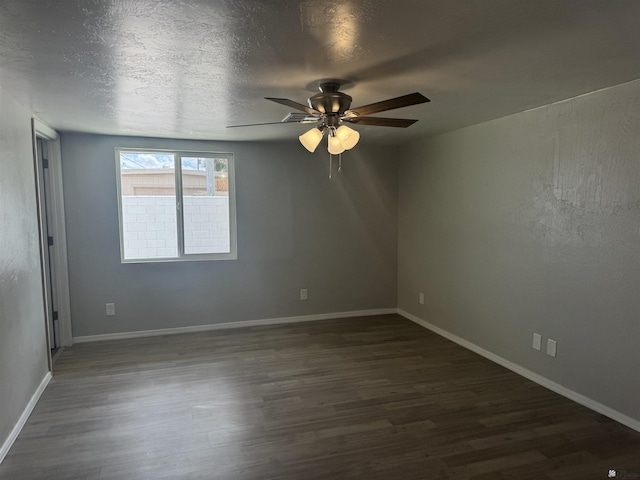 spare room with ceiling fan, baseboards, a textured ceiling, and dark wood finished floors