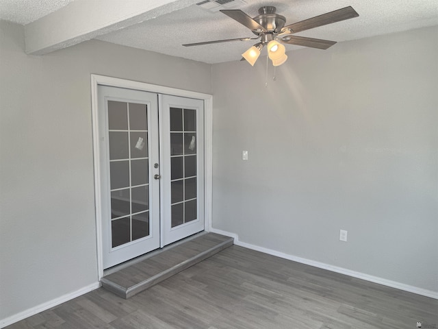 spare room with french doors, baseboards, a textured ceiling, and wood finished floors