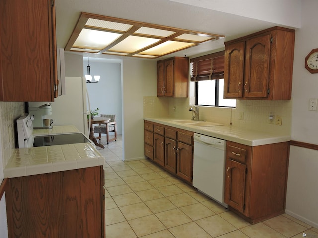 kitchen with a chandelier, tasteful backsplash, white dishwasher, stove, and sink